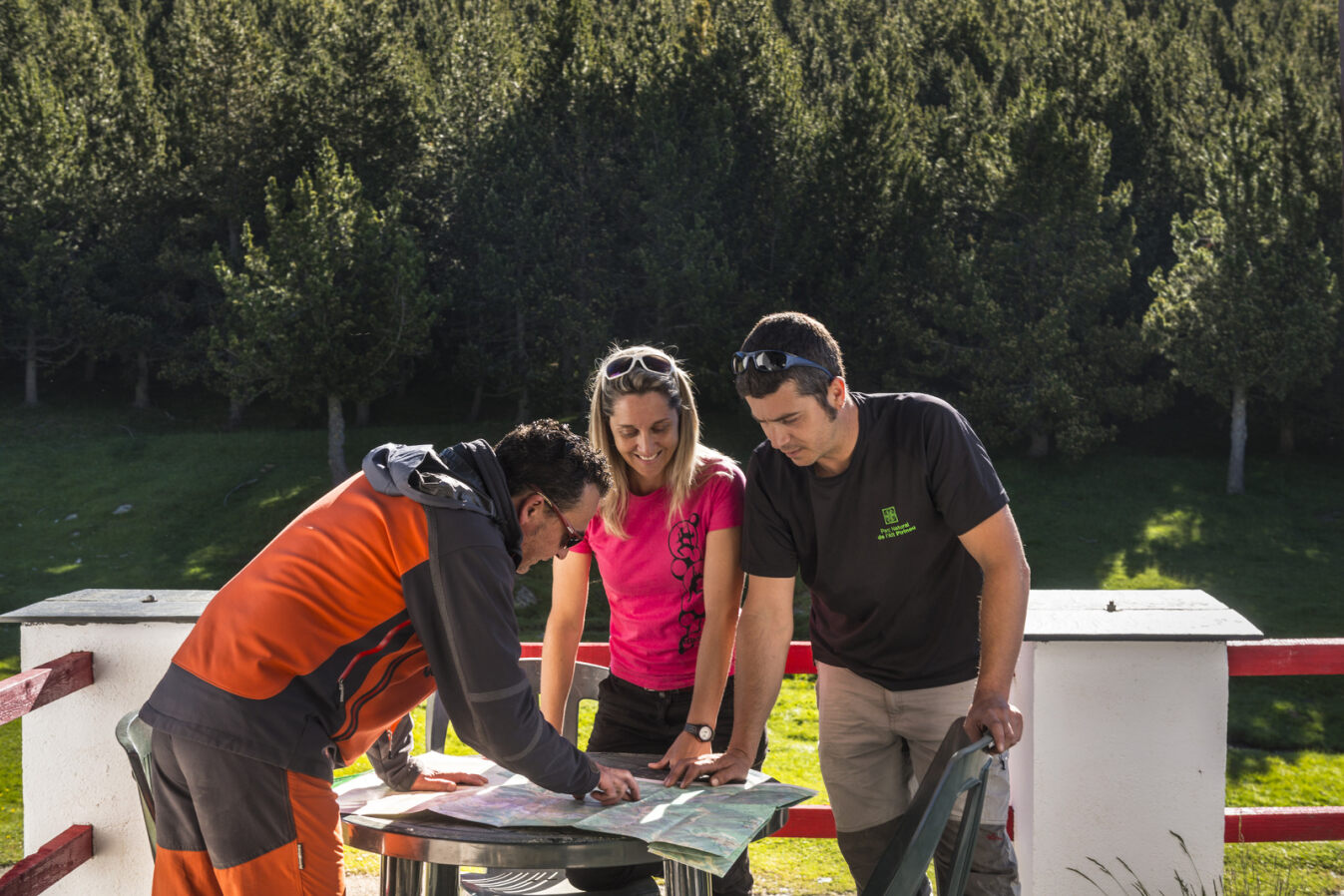 Grup de 3 excursionistes mirant i comentant un mapa